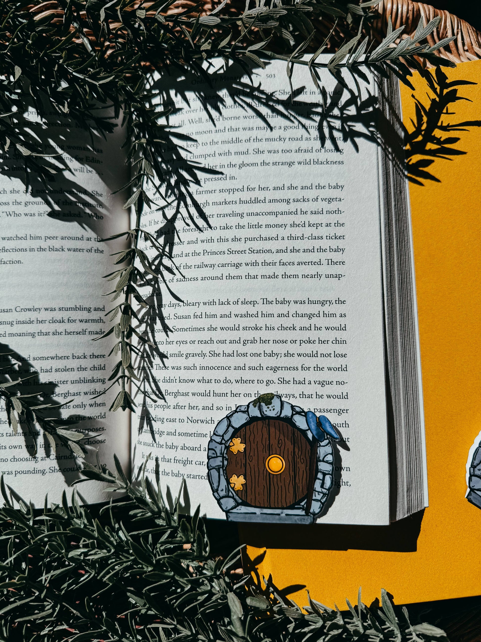 Open book with a hobbit hole illustration on a yellow background