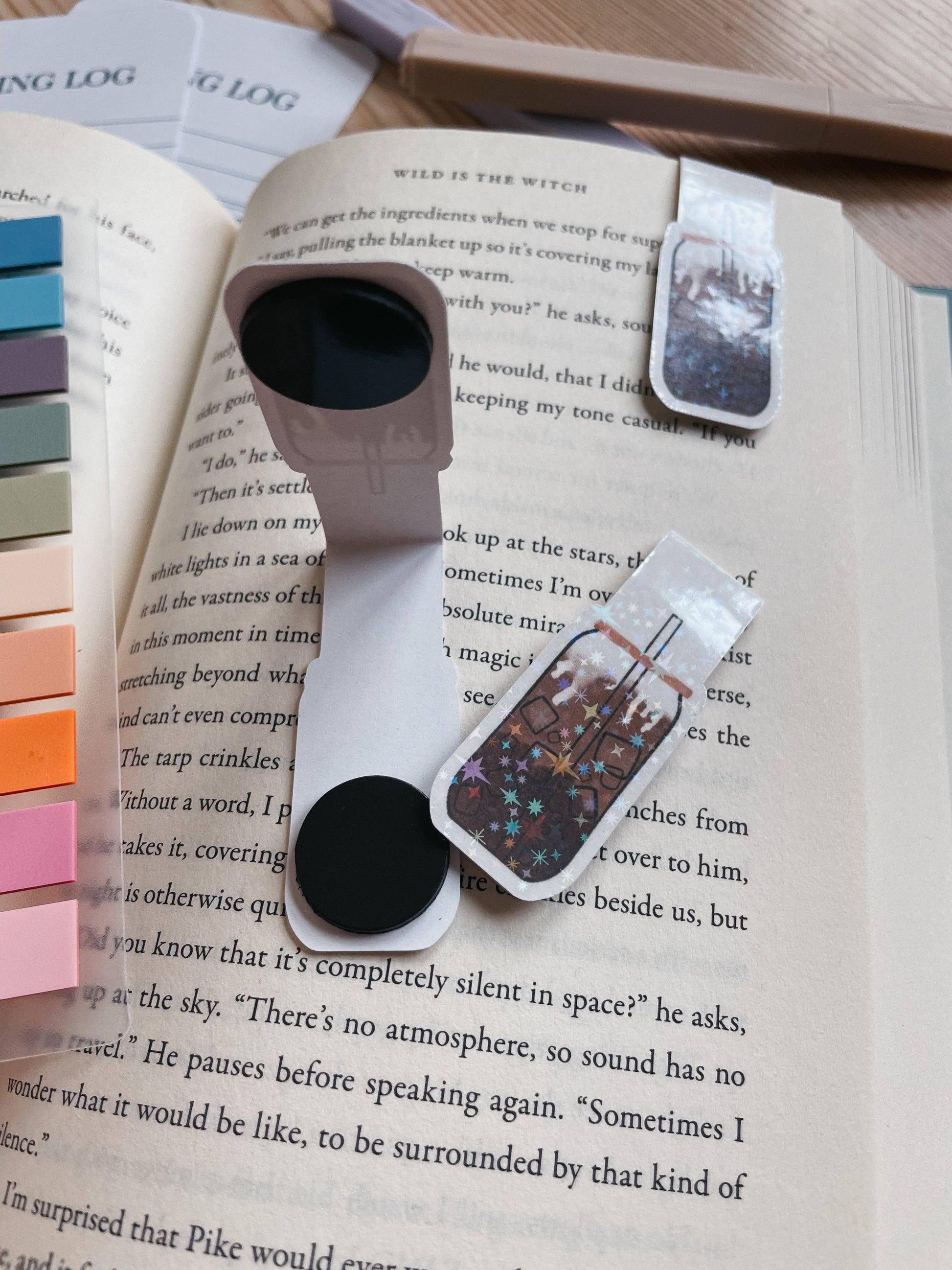 Two smartphone holders with decorative straps on an open book