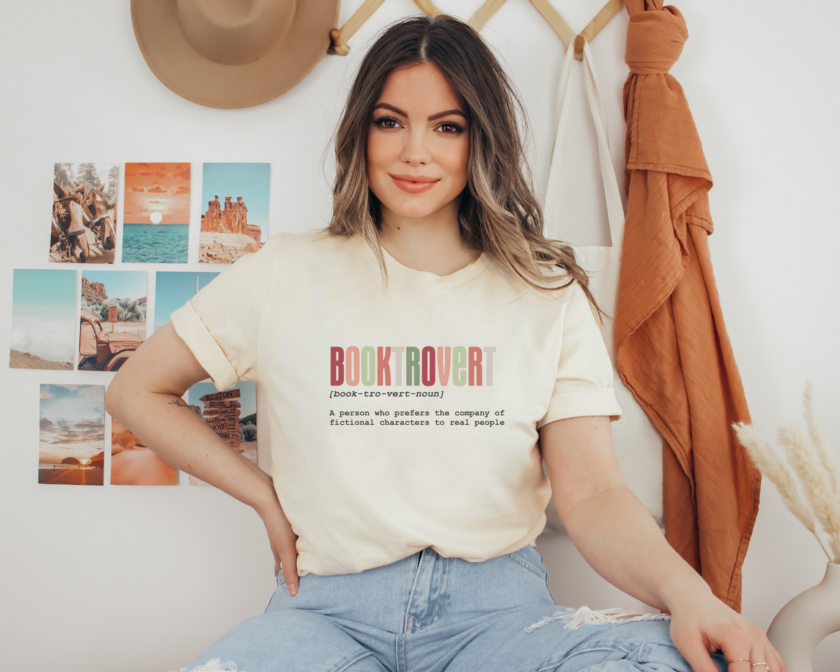 Woman wearing a 'Book Rover' t-shirt in a room with decor elements.