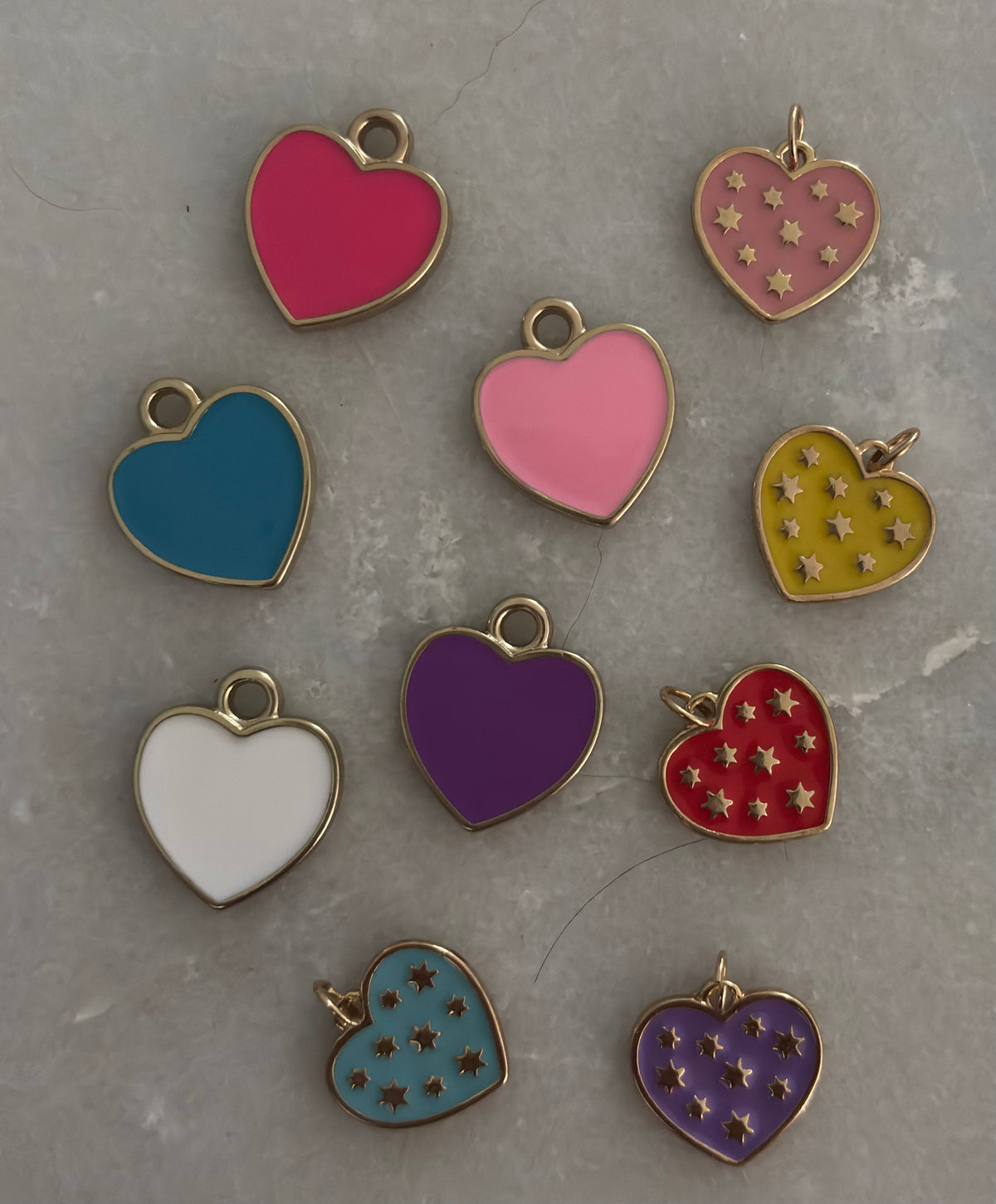 Colorful heart-shaped charms on a gray surface