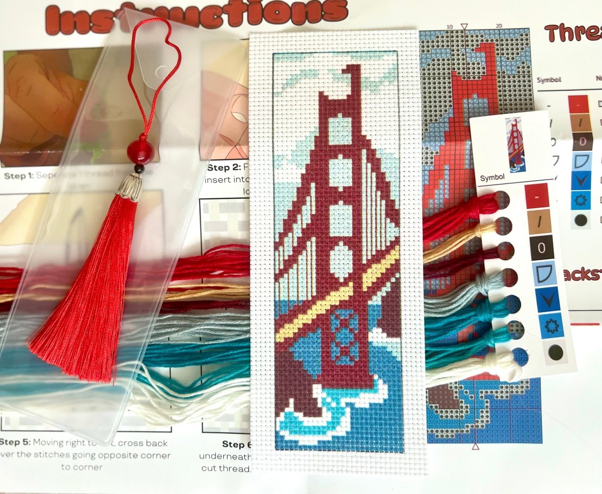 Cross-stitch kit with Golden Gate Bridge design, threads, and instructions.