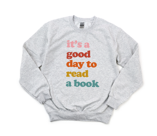 Gray sweatshirt with colorful text 'it's a good day to read a book' on a white background