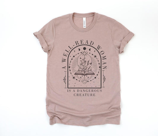 Mauve t-shirt with 'A well-read woman is a dangerous creature' design on a white background