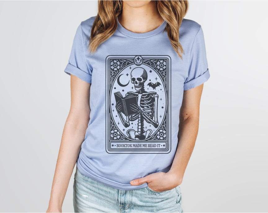 Person wearing a light blue t-shirt with a skeleton design on a plain background