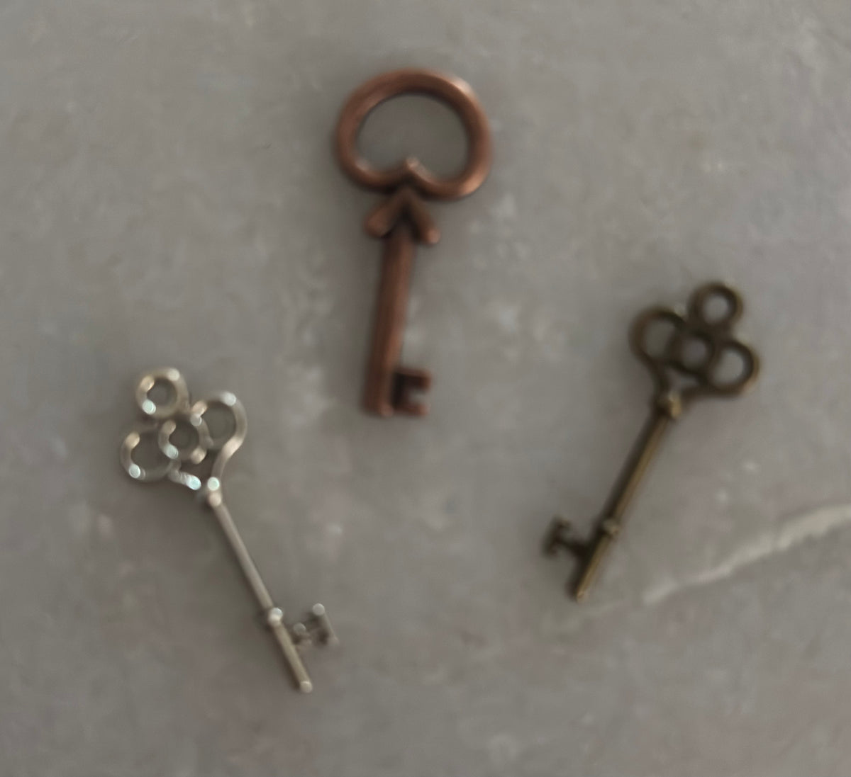 Three decorative keys on a textured gray surface