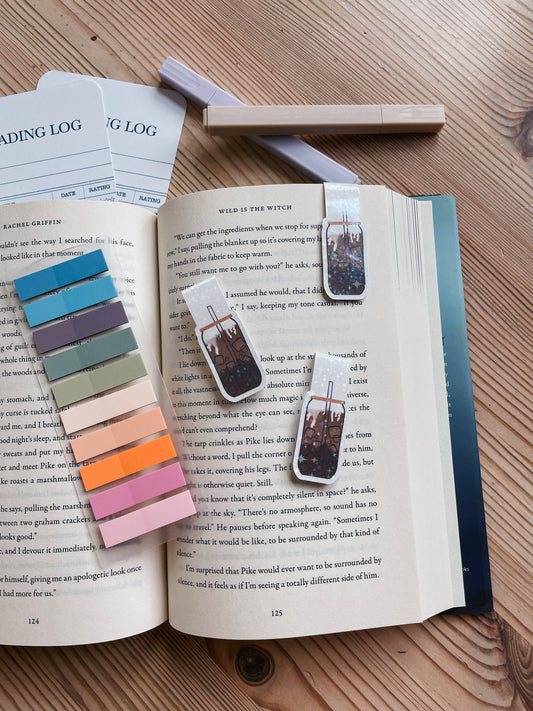 Open book with colorful bookmarks and a color swatch on a wooden surface