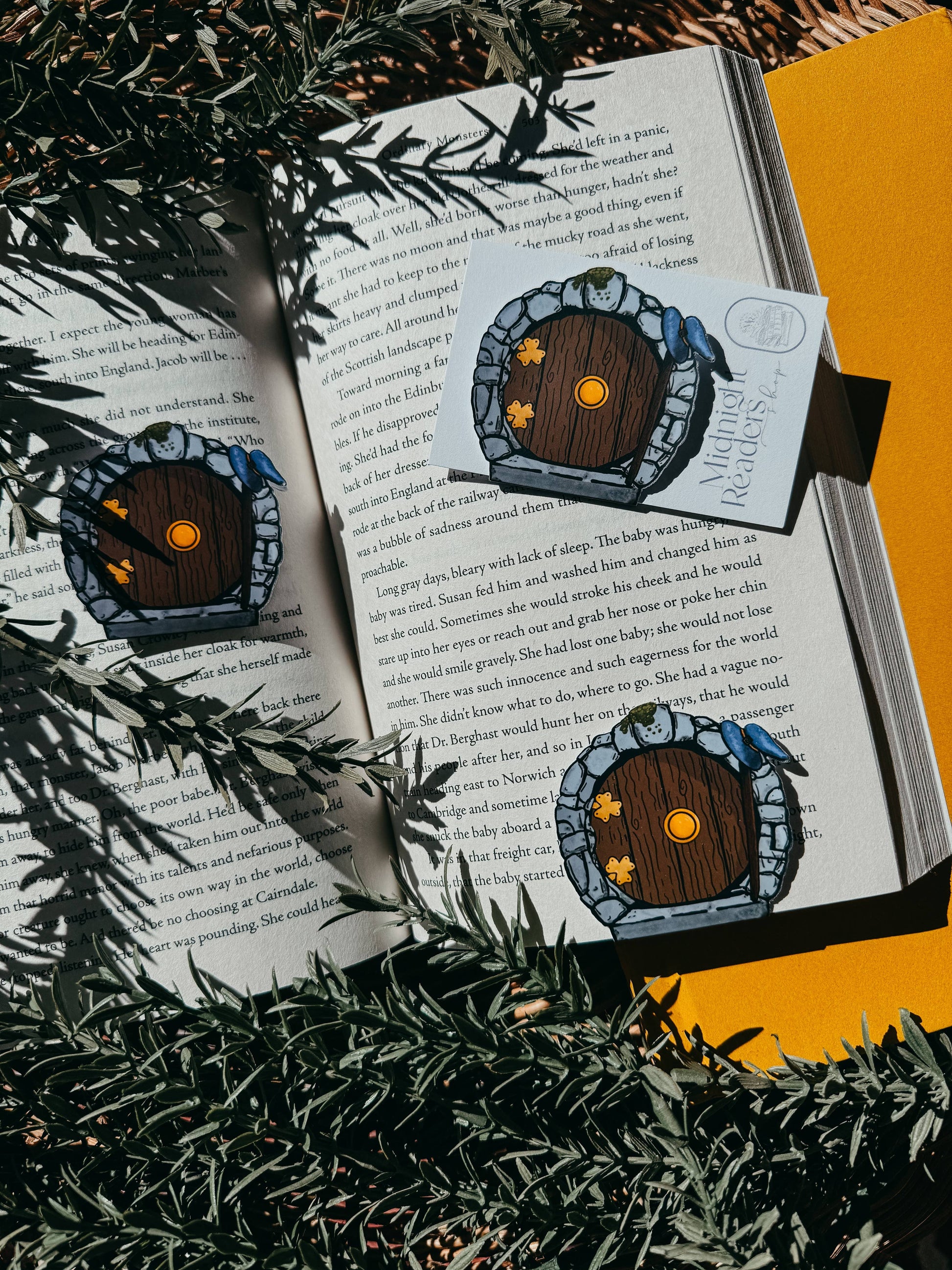 Book with decorative hobbit door bookmarks on a yellow background