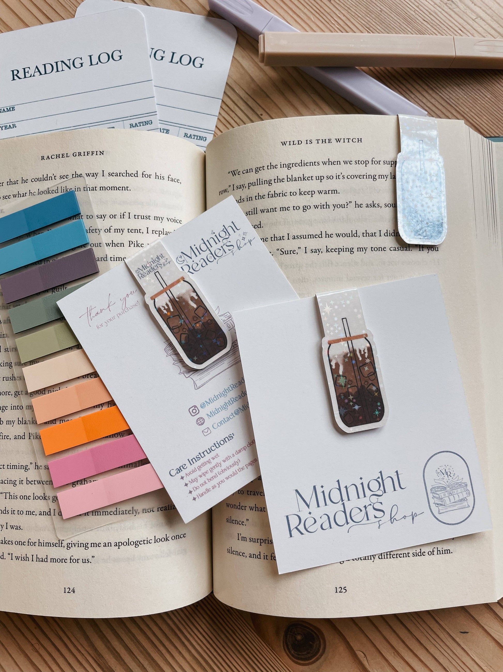 Open book with bookmarks and color swatches on a wooden surface