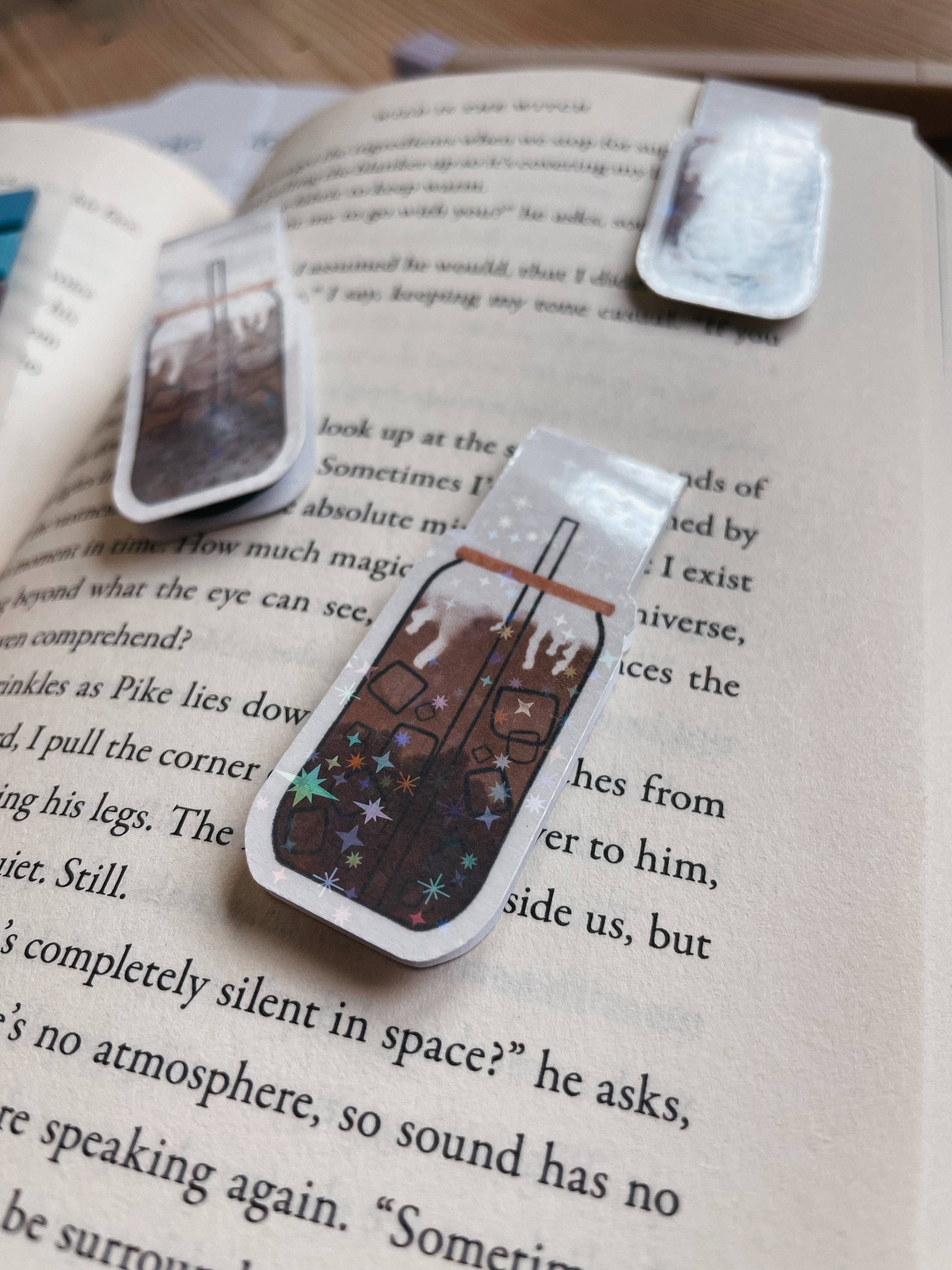 Three decorative bookmarks on an open book with text.